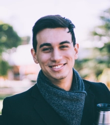 a young man with short hair wearing a blue scarf