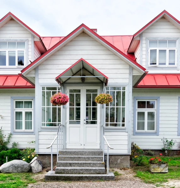 a red roof house covered in wooden panels at countryside